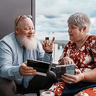 Deaf couple communicating using sign language and a speech-to-text mobile app at an airport.