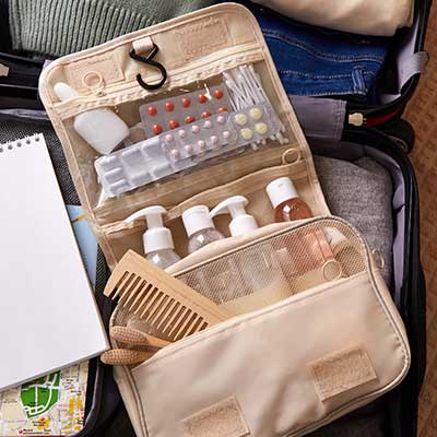 Open suitcase containing clothing, toiletries and prescription medication prepared for travel.