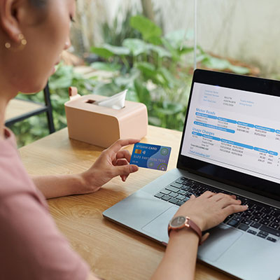 Traveller booking flights online using a laptop and credit card.